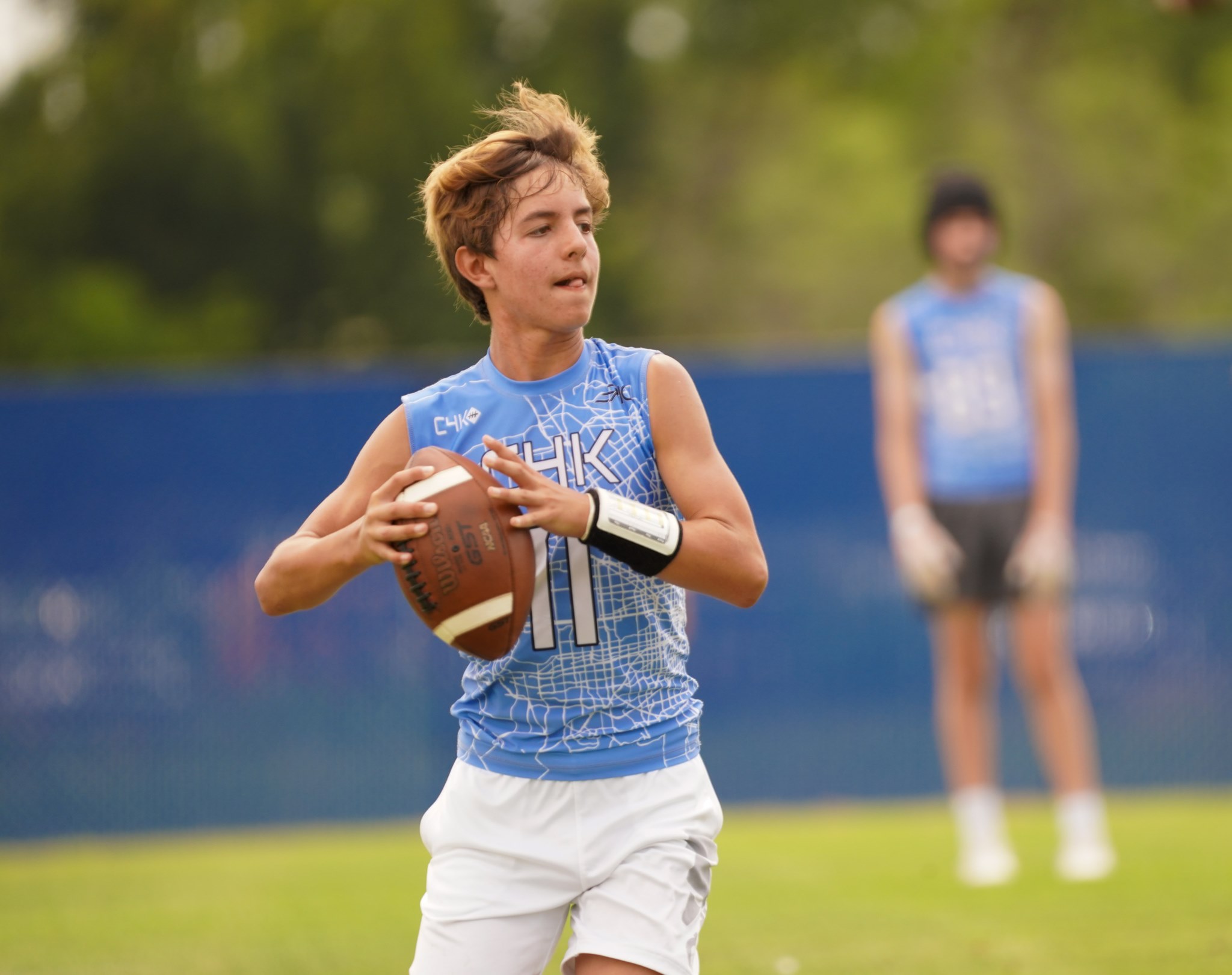 Teen holding football on field