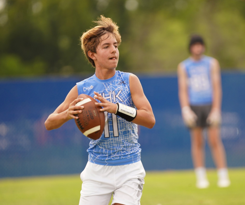 Teen holding Football on field