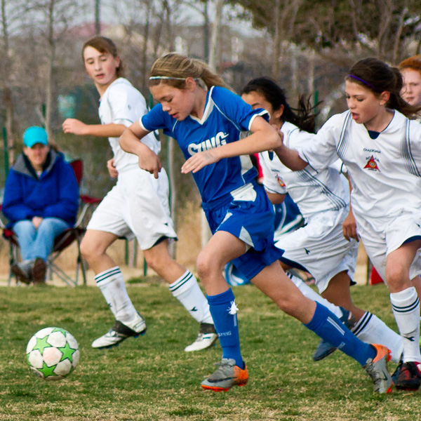 girl soccer player kicking ball